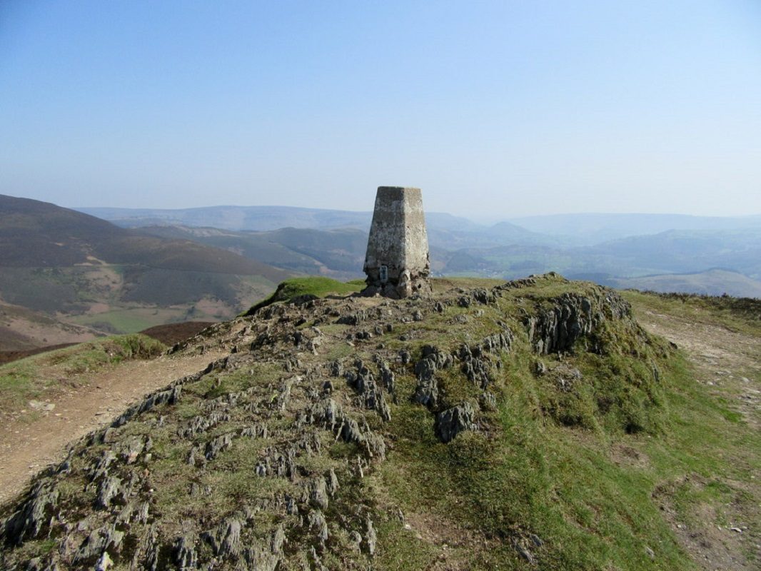 Trig point on the top of Moel Morfydd, about 10 miles from Caer Ogyrfan. Photo by John H Darch, CC-BY 2.0